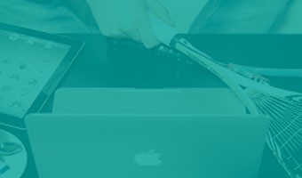 auf Schreibtisch liegen Laptop und Tennisschläger